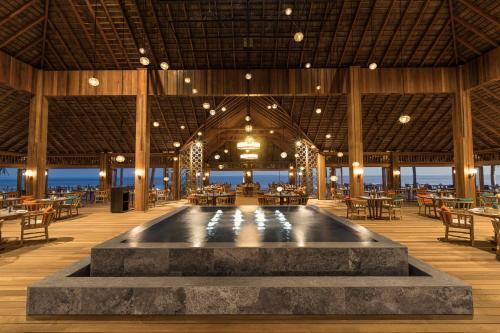 a restaurant with a pool in the middle of a room at Hurawalhi Island Resort in Kuredu