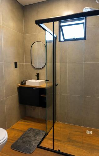 a bathroom with a sink and a mirror at Chalé em laguna in Pescaria Brava
