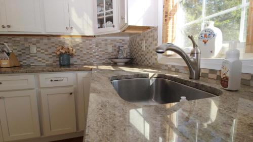 a kitchen with a stainless steel sink and a window at Ca De Cha in West Cape May