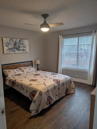 a bedroom with a bed with a comforter and a window at Entire One Bedroom Condo with AC, Wifi, & Pool in San Antonio