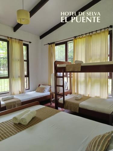 a bedroom with three bunk beds and a sign that reads hotel deylanlepire at Hotel de selva EL PUENTE in Villa Tunari