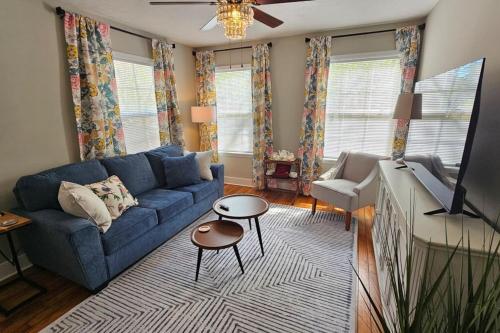 a living room with a blue couch and a television at The Tea CottageStylishRain ShowerLocation in Starkville