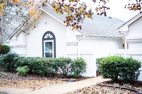 a white house with trees and a sidewalk at Spacious Golf Retreat with Sunset Views in Columbus