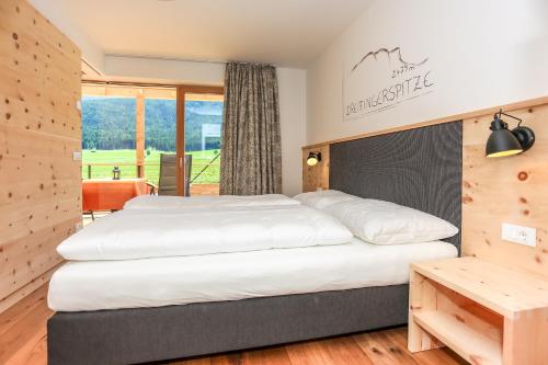a bedroom with a large bed and a table at Lerchnhof in Valdaora