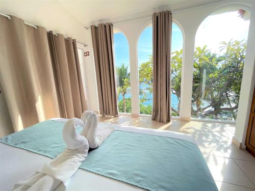 a bedroom with two beds and a view of the ocean at Villas & Resort Luz de Luna in Santa Cruz Huatulco