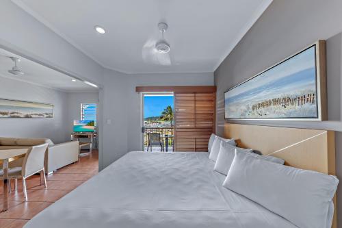a bedroom with a bed with a view of the ocean at at Boathaven Bay Holiday Apartments in Airlie Beach