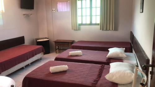 a hotel room with two beds and a window at Dormitório Dourada Costa in Baía Formosa