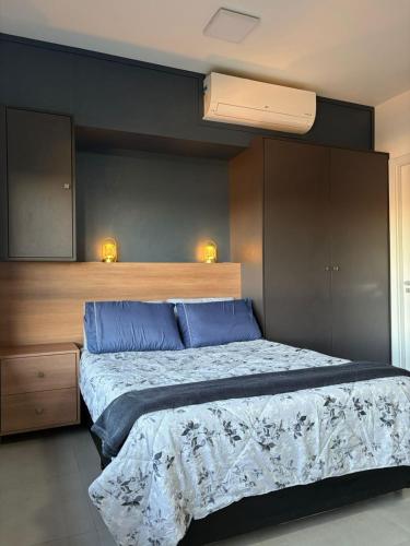 a bedroom with a large bed with blue pillows at Loft with pool and garage, next to Bourbon in Porto Alegre