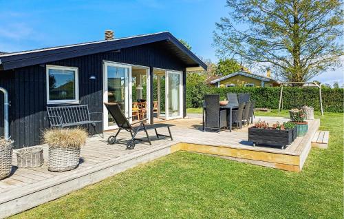 a house with a deck with a table and a chair at Awesome Home In Haderslev With Wifi in Haderslev