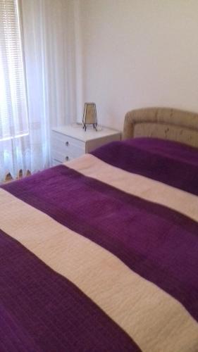 two beds in a bedroom with purple sheets at Holiday Home Hodo in Sarajevo