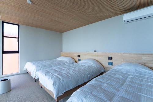 a bedroom with two beds and a window at KONA OCEAN Club in Awaji
