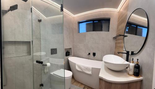 a bathroom with a sink and a toilet and a shower at Resort-style living -pool in Bass Hill