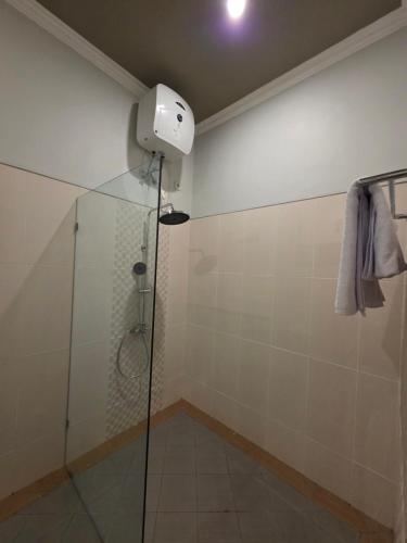 a shower with a glass door in a bathroom at Bukit Luwih House in Munduk