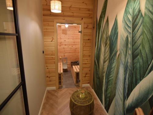 a hallway in a log cabin with a large painting on the wall at Very large apartment with private sauna in Stężyca