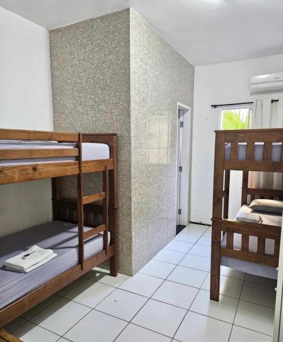 a room with bunk beds and a bathroom at Hostel Borogodó in Fortaleza