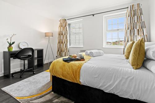 a bedroom with a large bed with a desk and a chair at Cheshire Gold- studio apartment, Warrington in Warrington