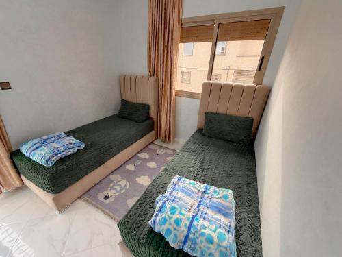a small room with two beds and a window at Modern and quiet apartment in Beni Mellal