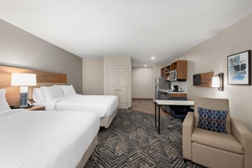 a hotel room with two beds and a desk at Candlewood Suites Mobile-Downtown by IHG in Mobile