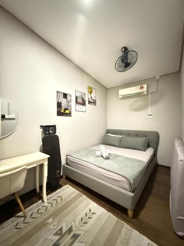 a small bedroom with a bed and a table at BELLA COTTAGE in Pantai Cenang