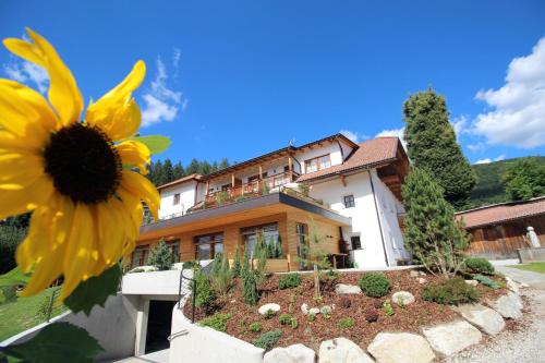 a small house with a flower garden in front of it at Apartments Im Winkl in Brunico