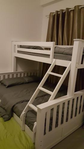 ein weißes Etagenbett mit einer Leiter drauf in der Unterkunft Dephane Apartment in Cameron Highlands