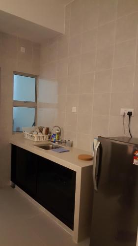eine Küche mit einer Spüle und einem Kühlschrank in der Unterkunft Dephane Apartment in Cameron Highlands