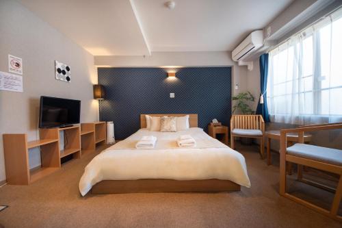 a hotel room with a large bed and a desk at Hotel Neiraku in Nara