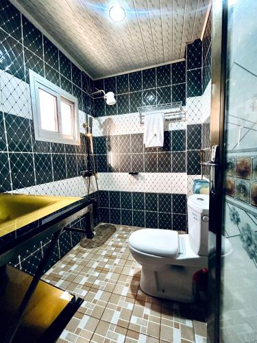 a bathroom with a toilet and a sink and a tub at FOCUS hotel in Baham