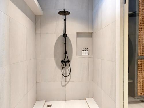 a bathroom with a shower with white tiles at Maehaad Bay Resort - SHA Plus in Mae Haad