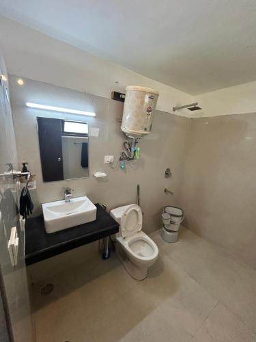 a bathroom with a toilet and a sink at Hotel Devidyar in Manāli