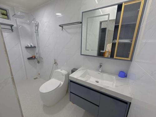 a white bathroom with a sink and a mirror at SU HOUSE Huế in Hương Trà