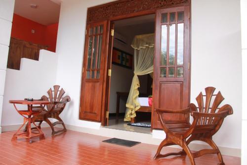 a room with two chairs and a table and a mirror at A One Calm Palace in Mirissa