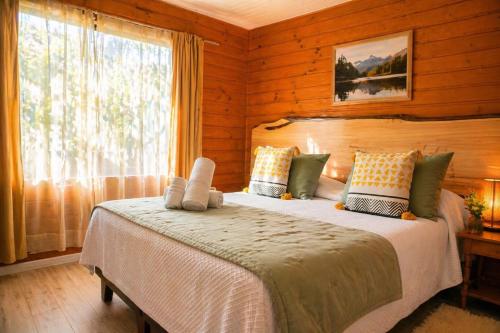 a bedroom with a large bed with a window at Hotel El Coihue in Pucón