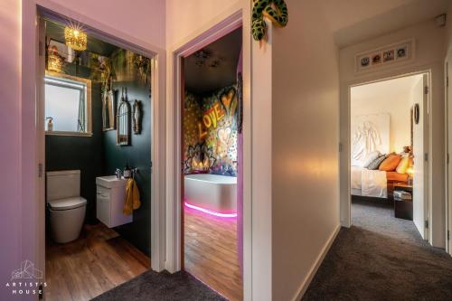 a bathroom with a tub and a sink and a bed at The Artist's House Wanaka in Luggate
