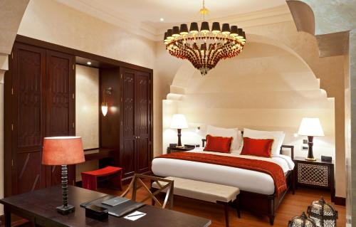 a bedroom with a large bed and a chandelier at Sofitel Legend Old Cataract in Aswan