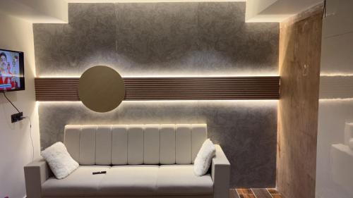 a living room with a white couch against a wall at Hotel D Lite Inn in Junagadh