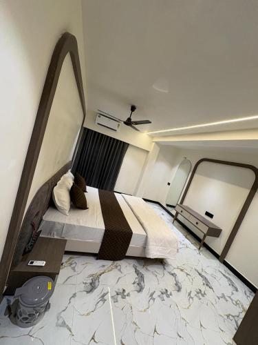 a bedroom with a large bed in a room at Hotel D Lite Inn in Junagadh