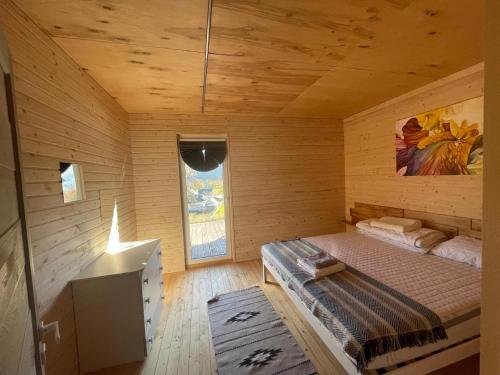 a room with a bed in a wooden cabin at B-House in Tyudov