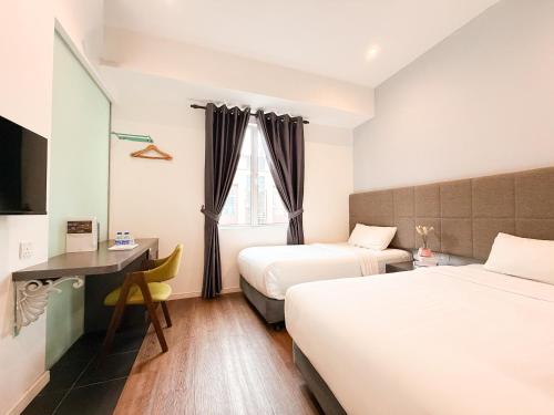 a hotel room with two beds and a desk at Havona Boutique Hotel - Mount Austin - Self Check-in in Johor Bahru