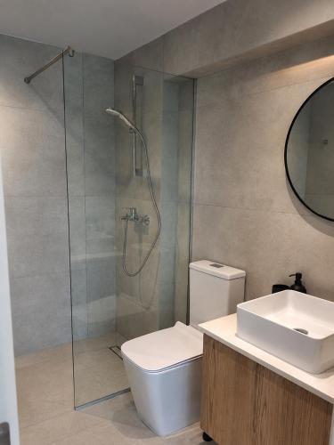 a bathroom with a shower and a toilet and a sink at Terrazza Suites in Paphos