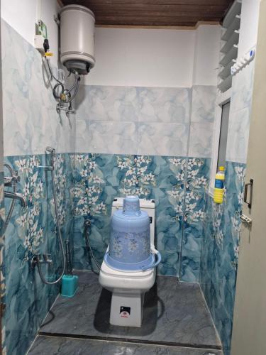 a bathroom with a blue toilet in a room at Aadharjun Homestay in Chidām