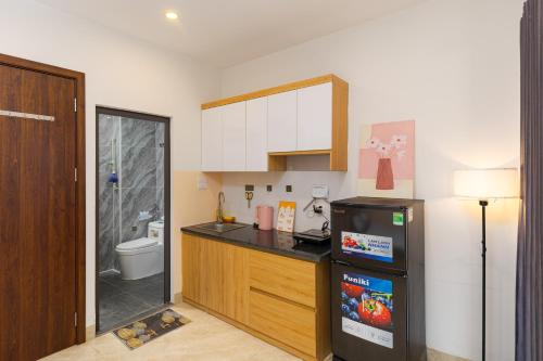 a kitchen with a sink and a refrigerator next to a toilet at Gấu Studio Ngoại Giao Đoàn in Hanoi