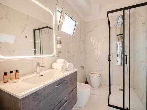 a white bathroom with a sink and a shower at Bari Home in Bari