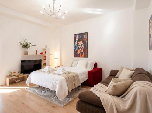 a white bedroom with a bed and a couch at Bari Home in Bari