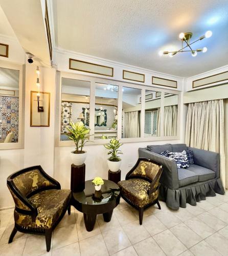 a living room with a couch and two chairs at Jupiter Homestay in Cabanatuan