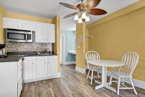 a kitchen with a table and a ceiling fan at Surf City Stay Motel Unit - Walk to Beach in Surf City