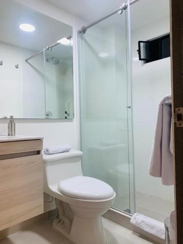 a bathroom with a toilet and a glass shower at Hotel 86 Suites in Bogotá
