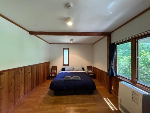 a bedroom with a bed with two shoes on it at Cabin D 3min walk Lake Saiko remote work BBQ, 5min drive Kawaguchi Lake Mt Fuji view in Narusawa