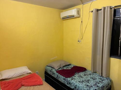 a small room with a bed and a air conditioner at Proximo ao Shopping e Aeroporto 2 Quartos com Ar e TV a Cabo in Várzea Grande