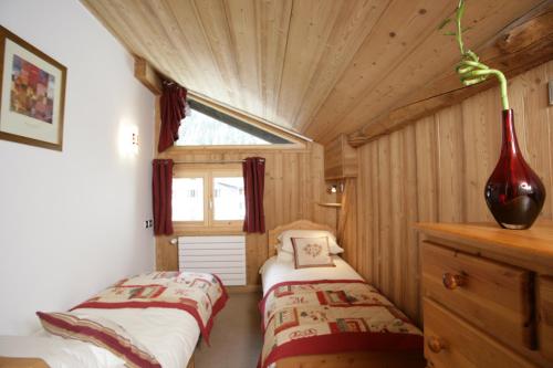 two beds in a small room with a window at La Grange De L'Aiguille in Chamonix